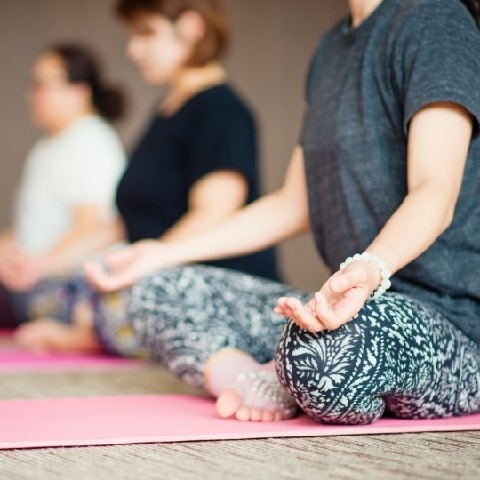 Yoga small People in easy pose on mats.